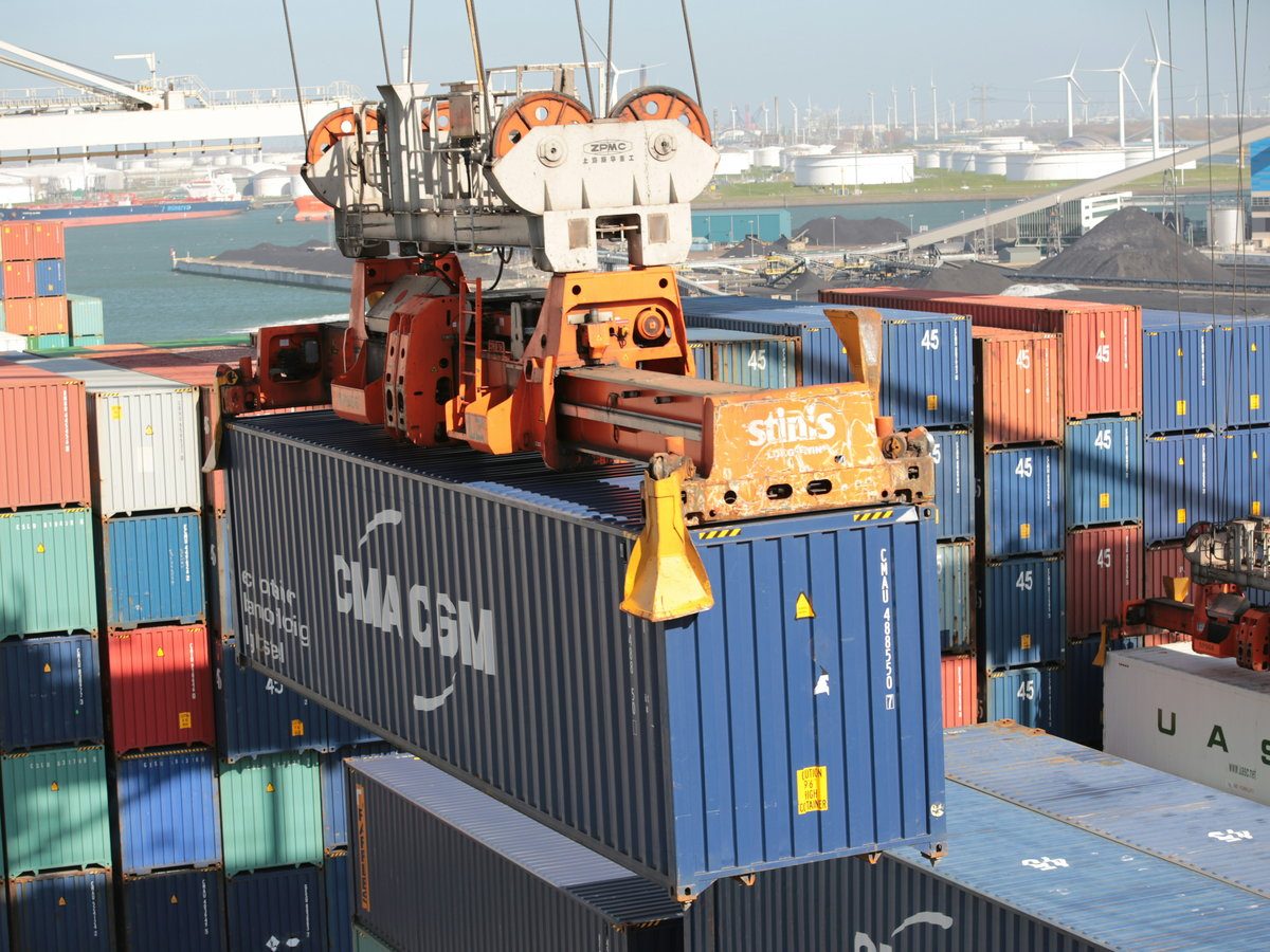 Crane spreader lifting a 40-foot container onto the stack