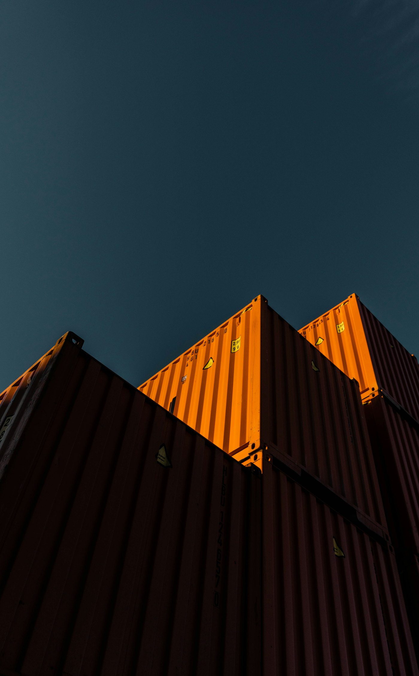 Shipping containers with their top edges lit by the sunset
